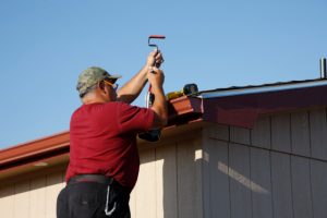 Beaverton Gutter worker Installing Downspout and Seamless Gutters