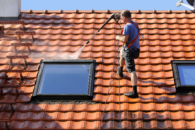 Beaverton worker doing a roof cleaning with high pressure washer