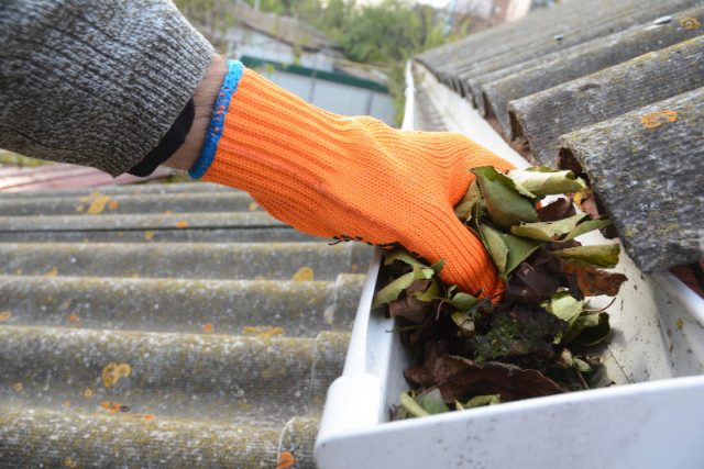 Gutter Cleaning Beaverton worker cleaning out leaves from gutter